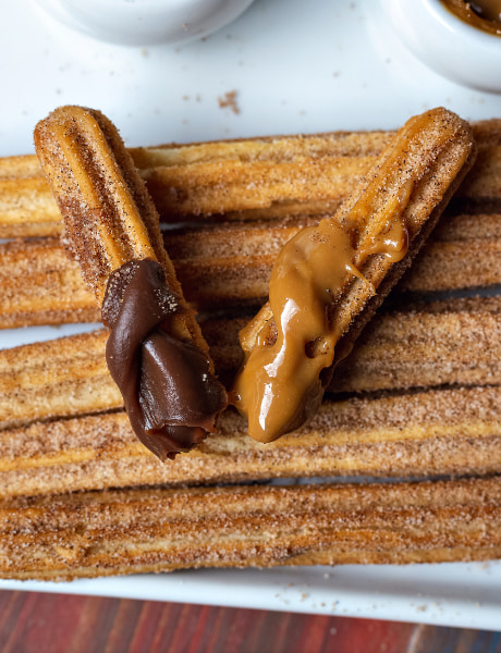 Churros com chocolate e doce de leite.