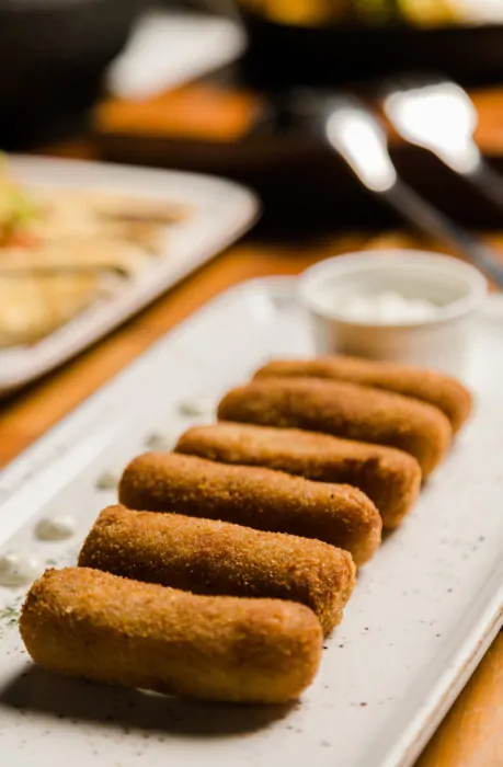 Receita de croquete de carne em um prato branco.